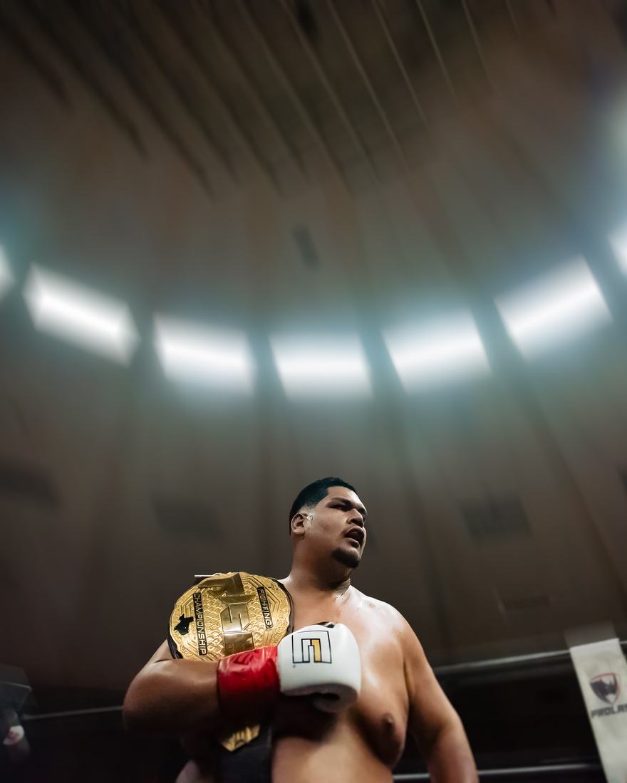Heavyweight champion holding his belt under the arena lights