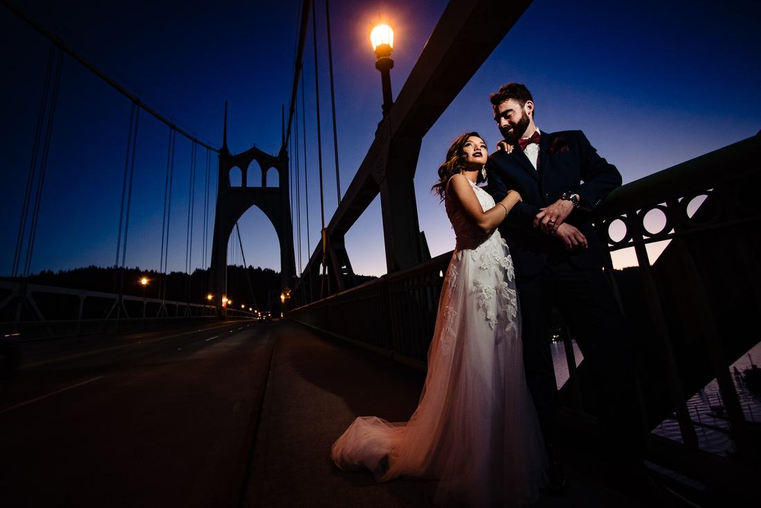 Bride and groom at dusk on the St. Johns Bridge under a street lamp